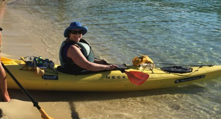 Carol Cram in a yellow kayak on the beach at Abel Tasman National Park in New Zealand