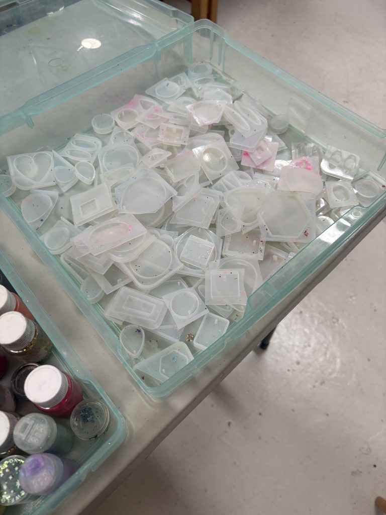 Box full of plastic moulds used to make resin art jewellry