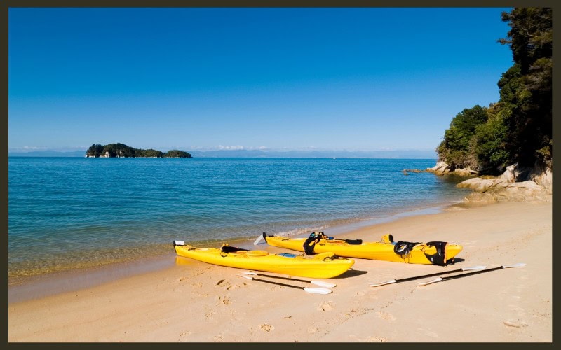 Kayaks on the beach at Abel Tasman National Park, the place for a multiday kayak and walk adventure with Wilson's