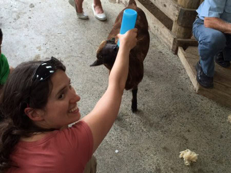 Julia Simpson feeding a lamb at Sheepworld in New Zealand
