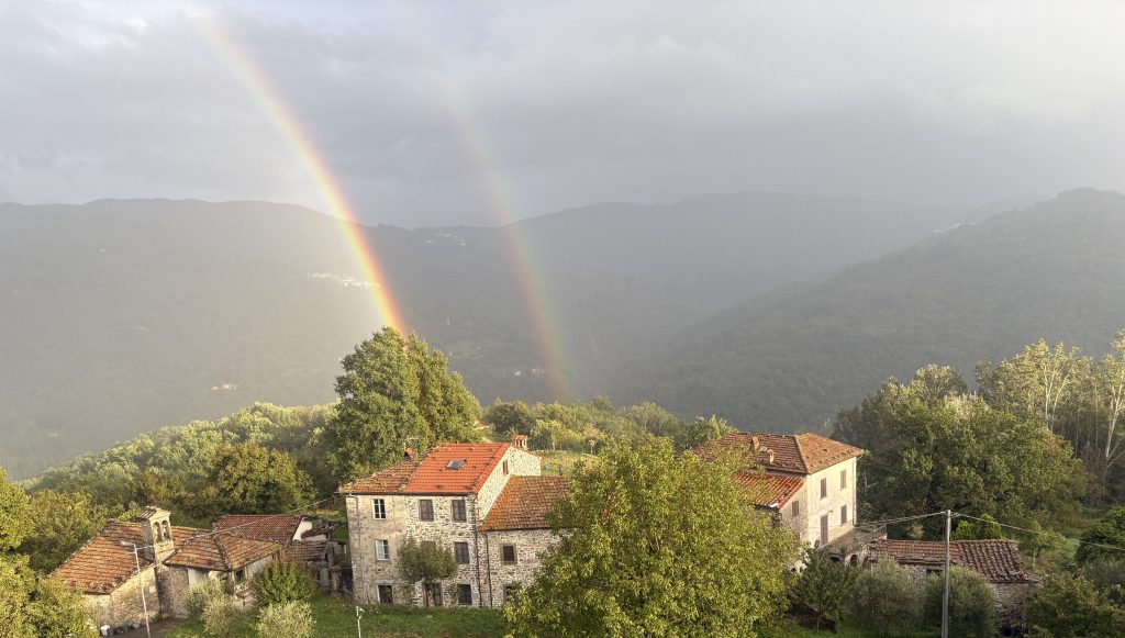 Rainbow arching over a view of mountains in Tuscany