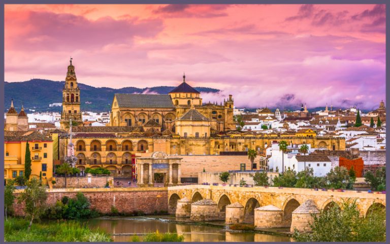 View of the Mezquita-Catedral and Roman Bridge in Córdoba at sunset, one of Spain’s most historic and atmospheric cities
