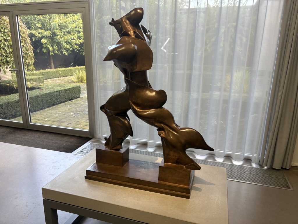 Umberto Boccioni's bronze Unique Forms of Continuity in Space beside a window looking onto a formal garden