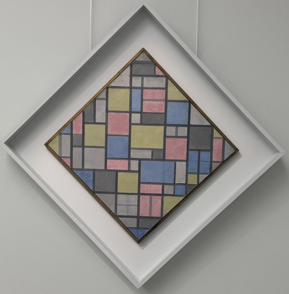Piet Mondrian's diamond-shaped lozenge composition with a grid of pastel pink, yellow, blue and grey rectangles in a white frame